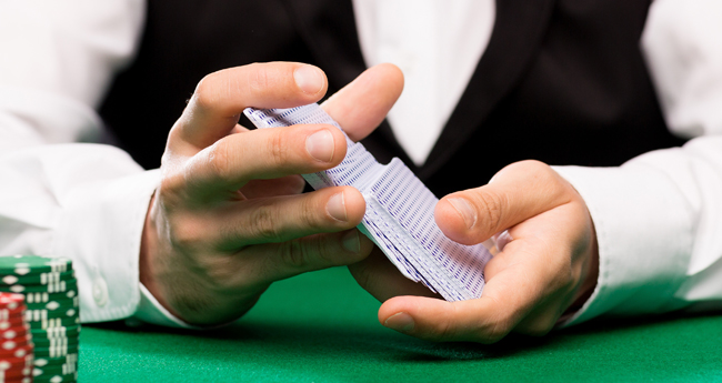 closeup image of a casino blackjack dealer holding a deck of cards ensuring clear visibility during playthrough